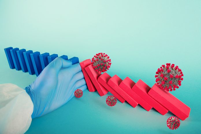 Concept of covid19 coronavirus pandemic with falling chain like a domino game. Contagion and infection progression stopped by a hand of a doctor. Cyan background