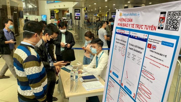 Hãng hàng không VietnamAirlines bố trí nhân viên và bàn hướng dẫn khách khai báo y tế trước lối vào soi chiếu an ninh