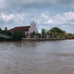 Tại ngã ba sông, ngôi nhà thờ được sơn màu hồng mái ngói đỏ nổi bật.